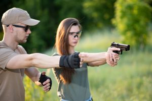 The shooting instructor teaches the backslider how to handle a weapon